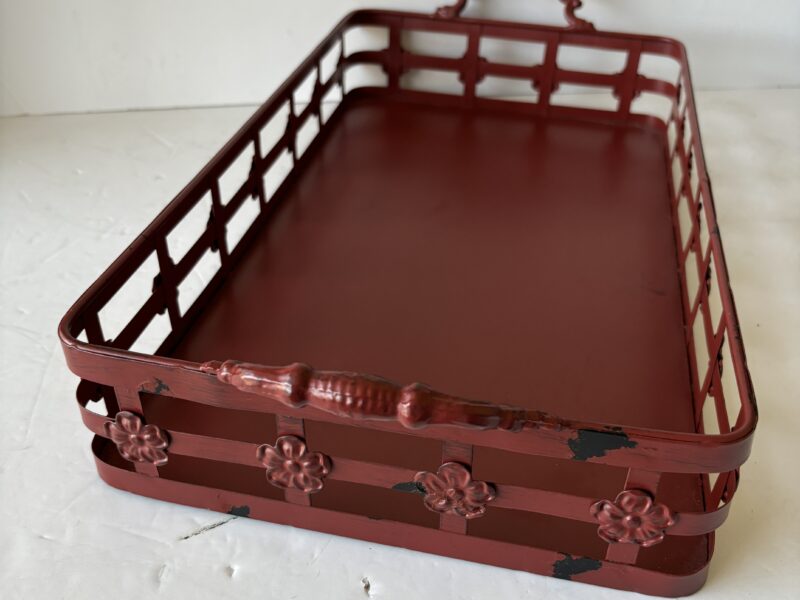 Red metal tray with handles and floral accent