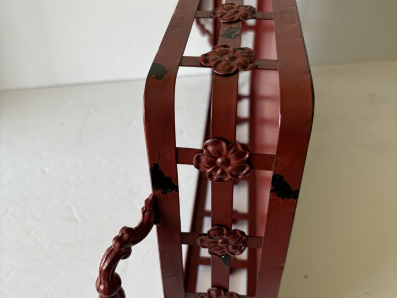 Red metal tray with handles and floral accent
