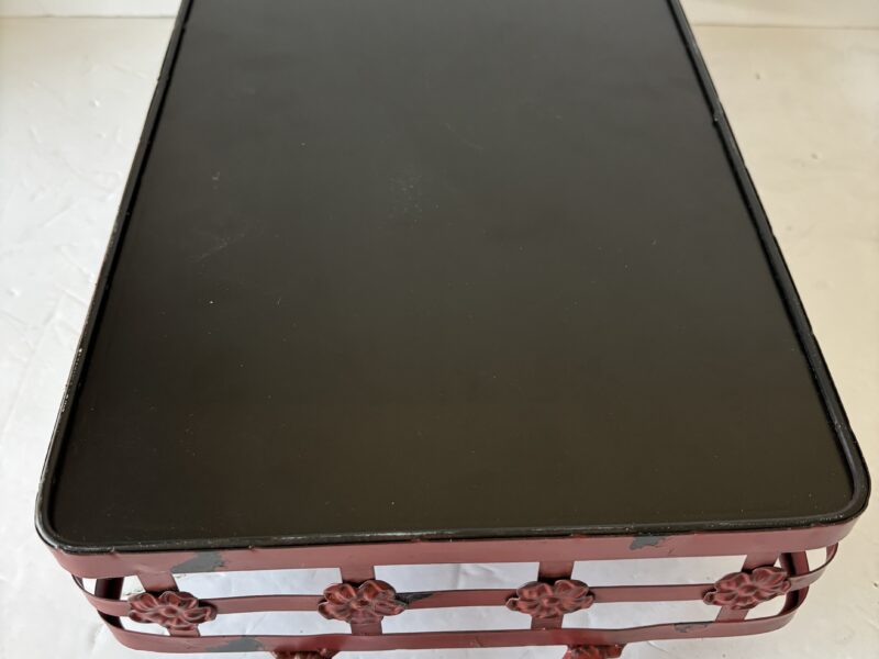 Red metal tray with handles and floral accent