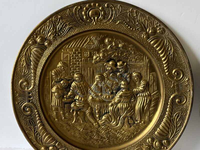 Pair of vintage 14" English Hammered Brass plates at dinner table and sailing ship