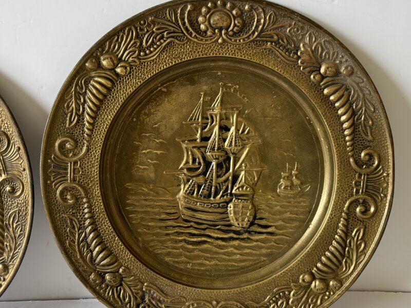 Pair of vintage 14" English Hammered Brass plates at dinner table and sailing ship