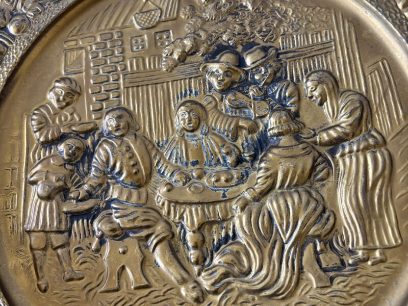Pair of vintage 14" English Hammered Brass plates at dinner table and sailing ship